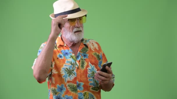 Красивый старший бородатый турист готов к отпуску на зеленом фоне — стоковое видео