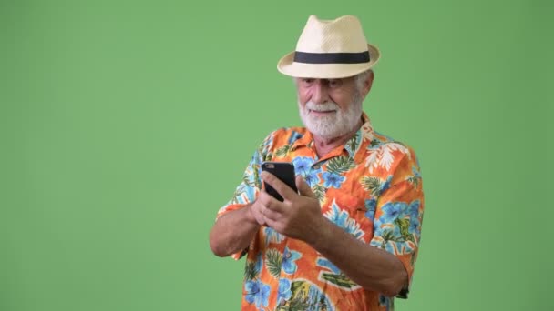 Bonito turista barbudo sênior pronto para férias contra fundo verde — Vídeo de Stock