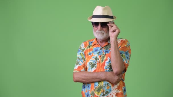 Pěkný starší vousatý turistické muž připraven na dovolenou před zeleným pozadím — Stock video