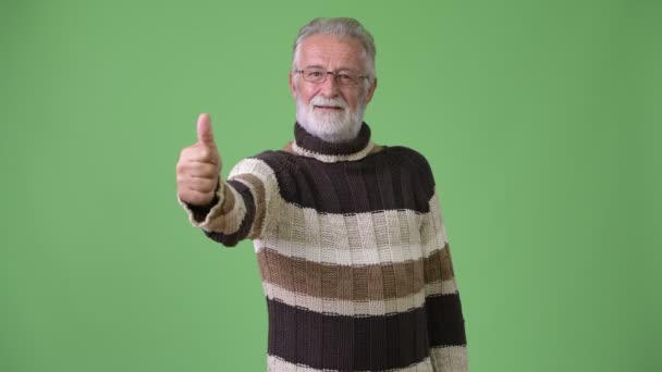 Bărbat frumos cu barbă, purtând haine calde pe fundal verde — Videoclip de stoc