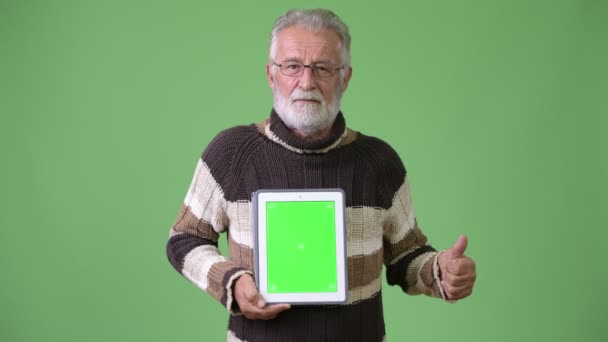 穿着保暖衣服的英俊的高级大胡子男子在绿色背景 — 图库视频影像