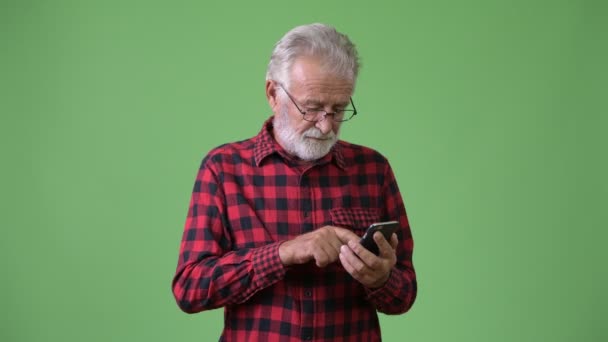 Pěkný starší vousatý muž proti zeleným pozadím — Stock video