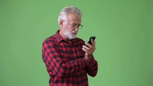 Schöner älterer bärtiger Mann vor grünem Hintergrund — Stockvideo