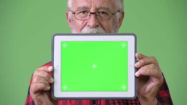 Üst düzey sakallı yakışıklı yeşil bir arka plana dayanır — Stok video