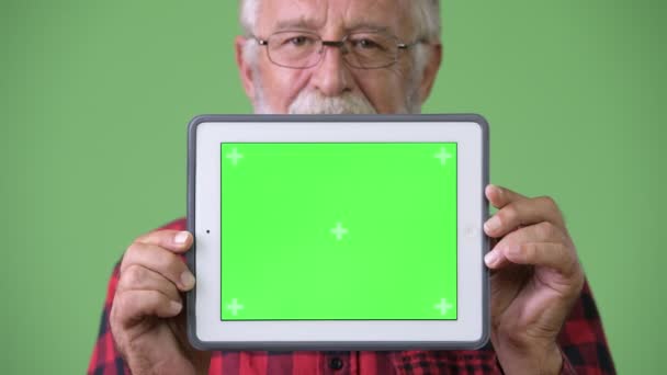 Üst düzey sakallı yakışıklı yeşil bir arka plana dayanır — Stok video