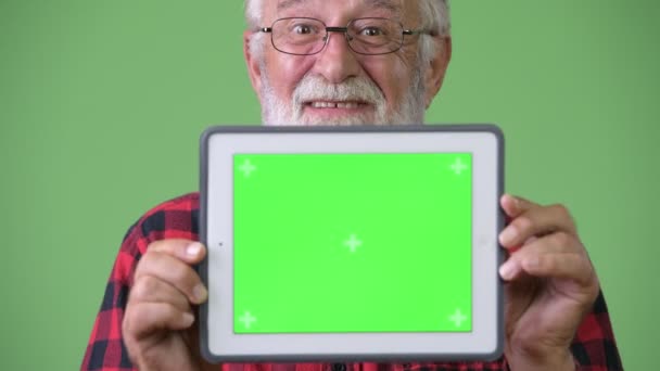 Handsome senior bearded man against green background — Stock Video