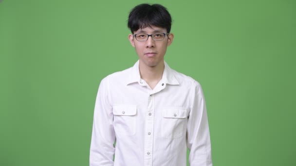 Junger glücklicher asiatischer Geschäftsmann lächelt mit verschränkten Armen — Stockvideo