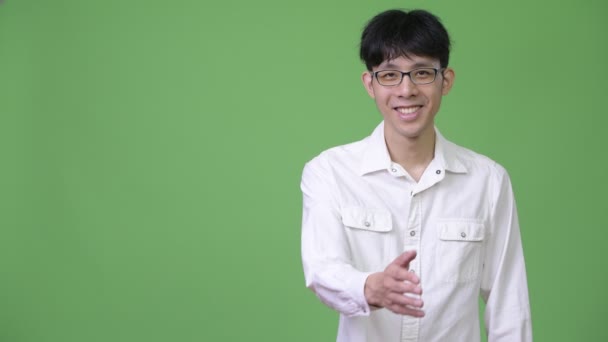 Young Asian businessman smiling while giving handshake — Stock Video