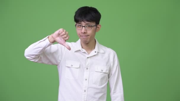 Young Asian businessman nodding head no and giving thumbs down — Stock Video