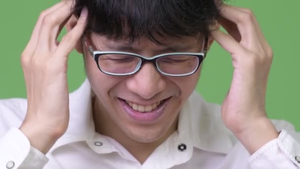 Genç Asyalı işadamı having baş ağrısı — Stok video