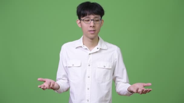 Young Asian businessman shrugging shoulders — Stock Video