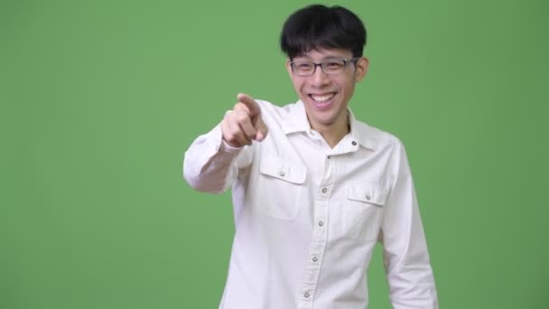 Glad ung asiatisk affärsman skrattar medan pekande finger — Stockvideo