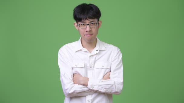 Wütender junger asiatischer Geschäftsmann mit verschränkten Armen — Stockvideo