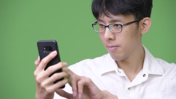電話を使用して若いアジア系のビジネスマン — ストック動画