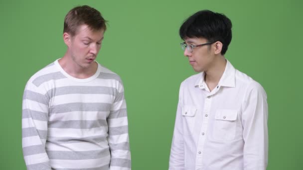 Deux jeunes hommes d'affaires multi-ethniques tristes donnant les pouces baissés — Video
