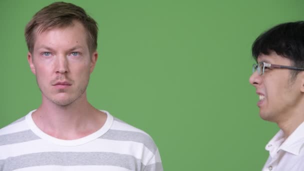 Joven hombre de negocios asiático enojado gritando a joven hombre de negocios escandinavo — Vídeos de Stock
