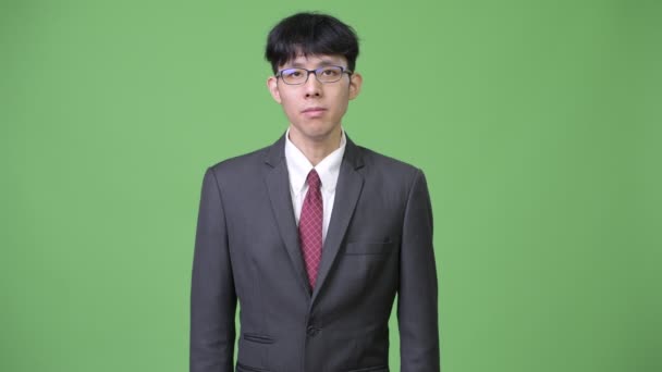 Młody biznesmen Azjatka na zielonym tle — Wideo stockowe