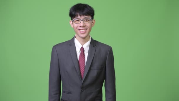 Junge glückliche asiatische Geschäftsmann lächelnd — Stockvideo