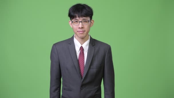 Молодой счастливый азиатский бизнесмен улыбается и пожимает руку — стоковое видео