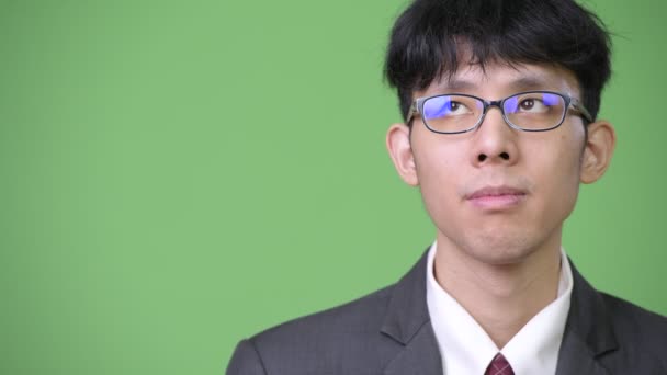 Young Asian businessman against green background — Stock Video