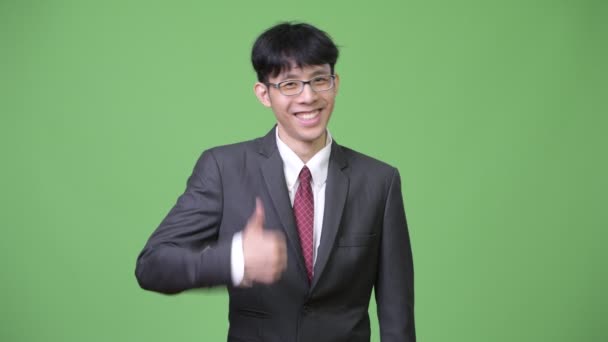 Jeune homme d'affaires asiatique heureux souriant tout en donnant pouces vers le haut — Video