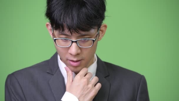 Молодой азиатский бизнесмен думает: — стоковое видео