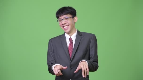 Young happy Asian businessman laughing while holding stomach — Stock Video