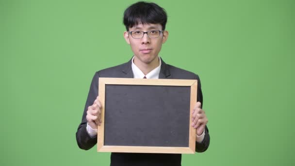 显示黑板的年轻的亚洲商人照相机 — 图库视频影像