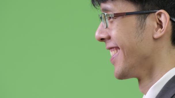 Profiel te bekijken van jonge Aziatische zakenman glimlachen — Stockvideo