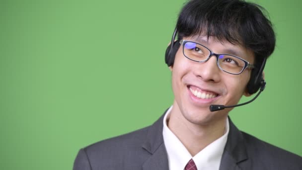 Ung glad asiatiska affärsman tänka och arbeta som call center representant — Stockvideo