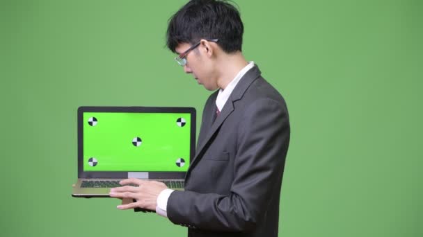 Young Asian businessman showing laptop to camera — Stock Video