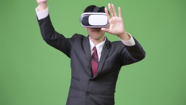 Jovem empresário asiático usando fone de ouvido realidade virtual — Vídeo de Stock