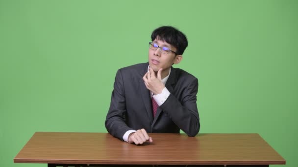 Jovem empresário asiático pensando enquanto olha para cima — Vídeo de Stock