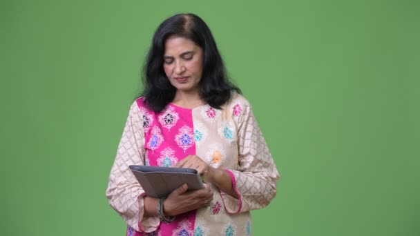 Reife glückliche schöne indische Frau nutzt digitales Tablet und bekommt gute Nachrichten — Stockvideo