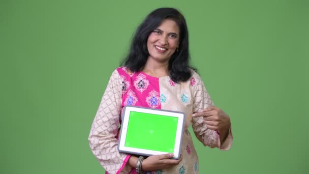 Зрілі щасливі красива Індійська жінка показ цифровий планшет і вказуючи пальцем — стокове відео