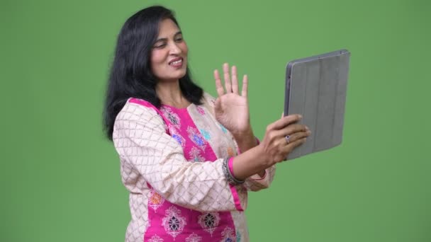 Mature happy beautiful Indian woman video calling with digital tablet — Stock Video