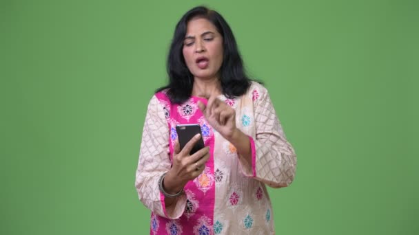 Mature serious Indian woman using phone while getting bad news — Stock Video