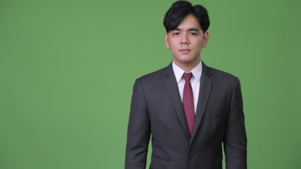 何かを示す若いハンサムなアジア系のビジネスマン — ストック動画