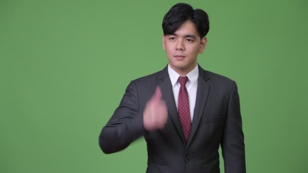 Молодой привлекательный азиатский бизнесмен подает большие пальцы — стоковое видео