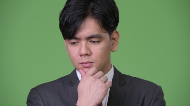 Junge traurige asiatische Geschäftsmann denken — Stockvideo