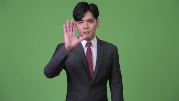 Jonge knappe Aziatische zakenman gebaren om te stoppen — Stockvideo