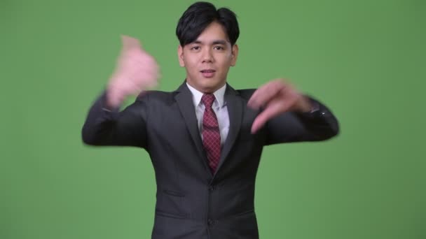 Mladí zmatený asijské podnikatel dává palec nahoru a dolů — Stock video