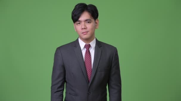 Молодий красивий азіатських бізнесмен, киваючи головою не — стокове відео