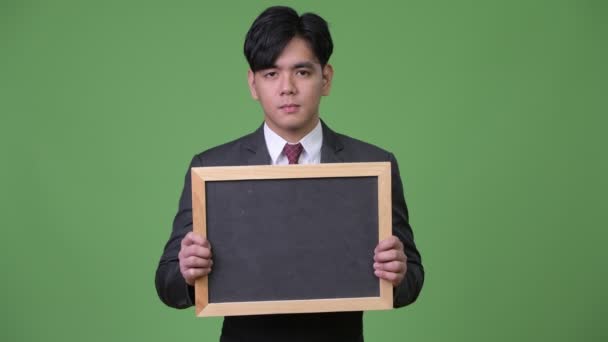年轻英俊的亚洲商人显示黑板 — 图库视频影像