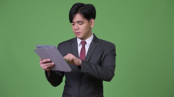 Jovem bonito empresário asiático usando tablet digital — Vídeo de Stock