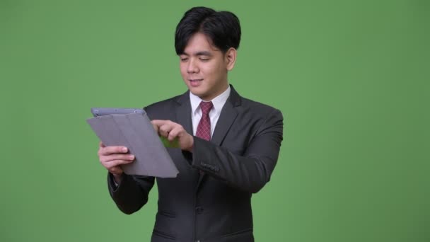 Mladý pohledný asijské podnikatel pomocí digitálních tabletu — Stock video