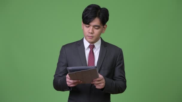 Fiatal csinos ázsiai üzletember segítségével digitális tabletta — Stock videók