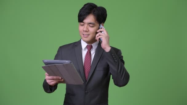 Mladý pohledný asijské podnikatel pomocí digitálních tabletu — Stock video
