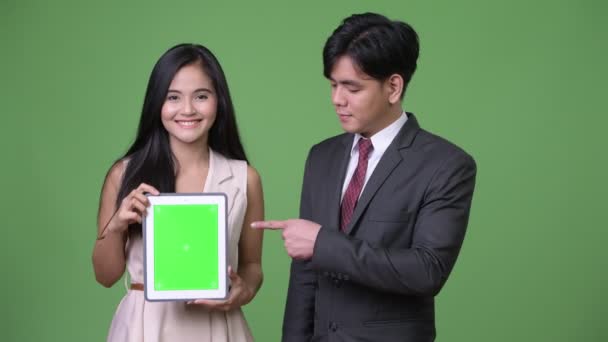 Молоді азіатські бізнес пару разом на зеленому тлі — стокове відео