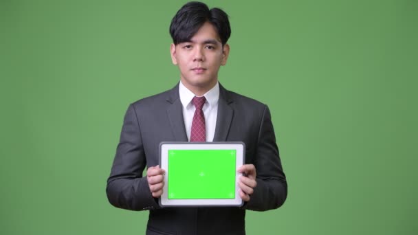 Jovem bonito empresário asiático usando tablet digital — Vídeo de Stock